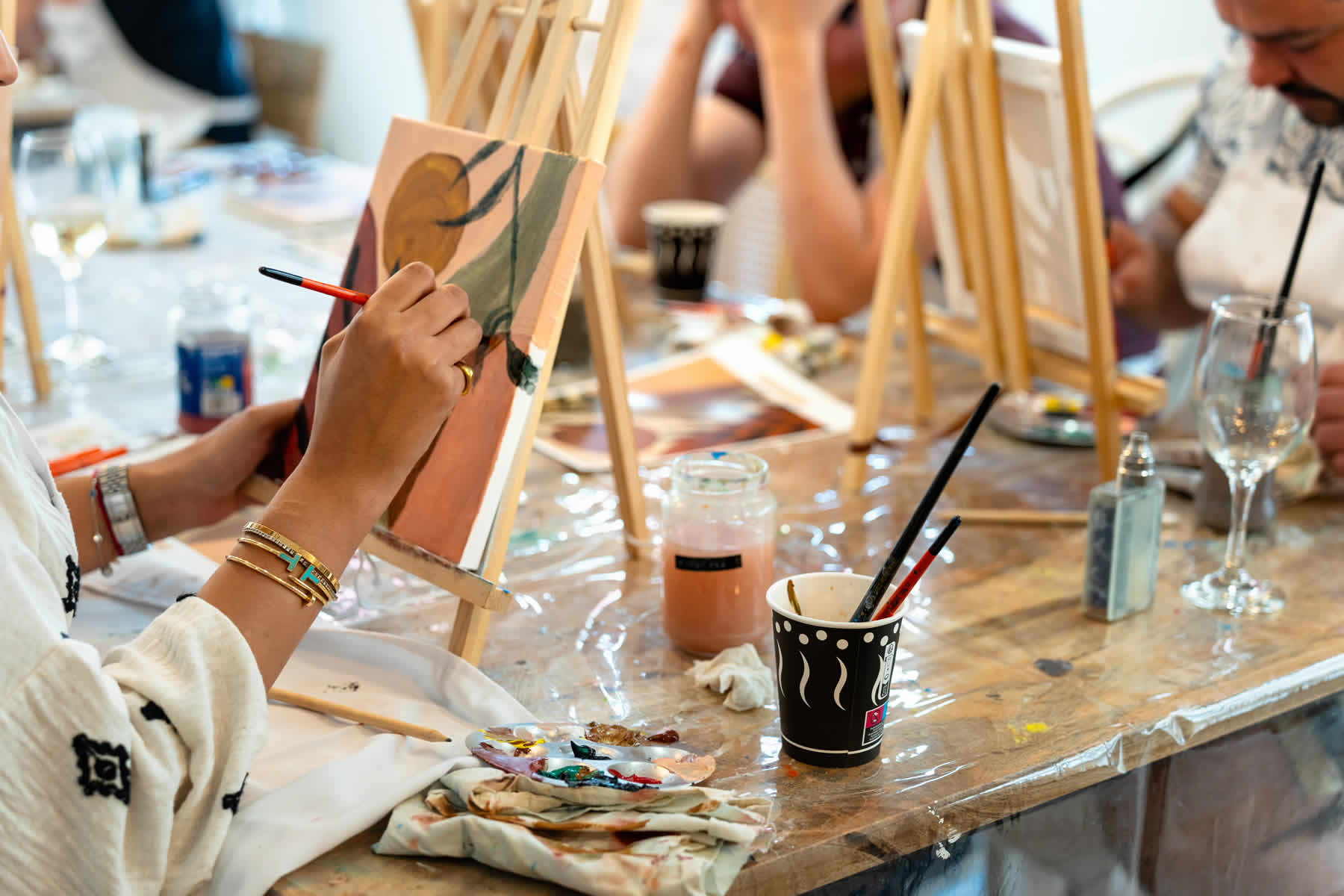 Personas pintando en lienzo durante un taller en Pausarte Estudio